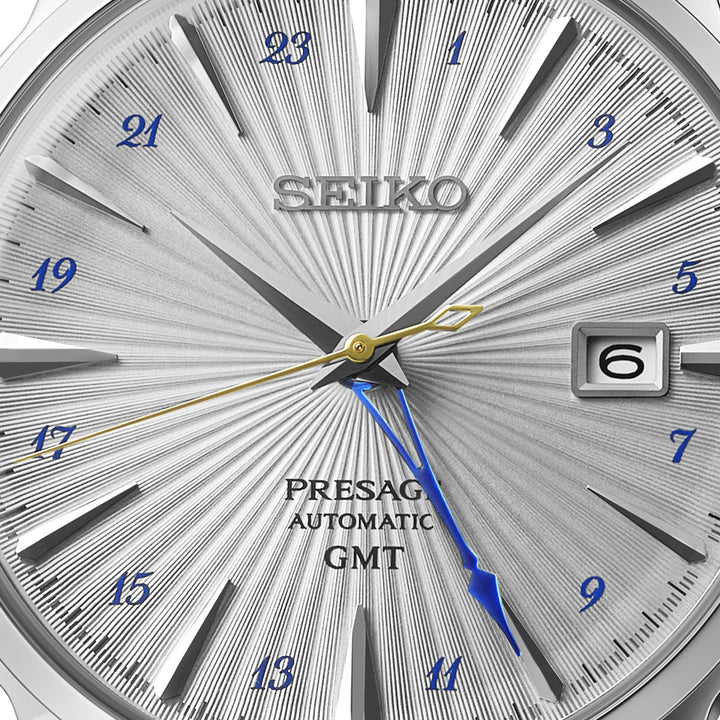 Seiko Presage Silver Bullet dial featuring deep pressed cocktail glass pattern, blue cursive Arabic numerals, gold swizzle-stick seconds hand and blue GMT hand