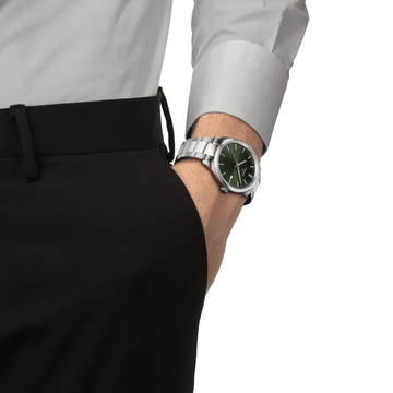 Man wearing Tissot PR 100 green dial watch with stainless steel bracelet
