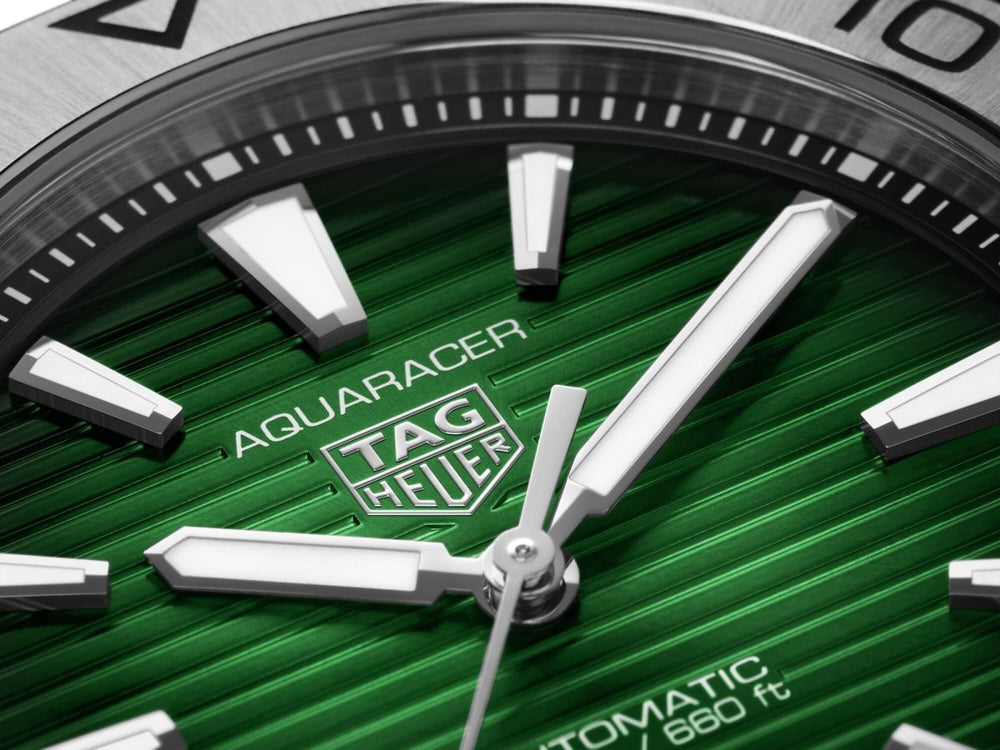 Close-up of TAG Heuer Aquaracer Professional 300 green dial and ceramic bezel showing brushed stainless steel case finishing