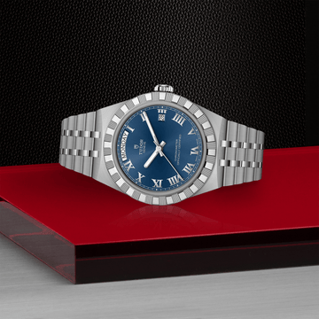 Day-Date watch TUDOR Royal with notched bezel,blue dial, and the day displayed at 12 o’clock and the date at 3 o’clock.